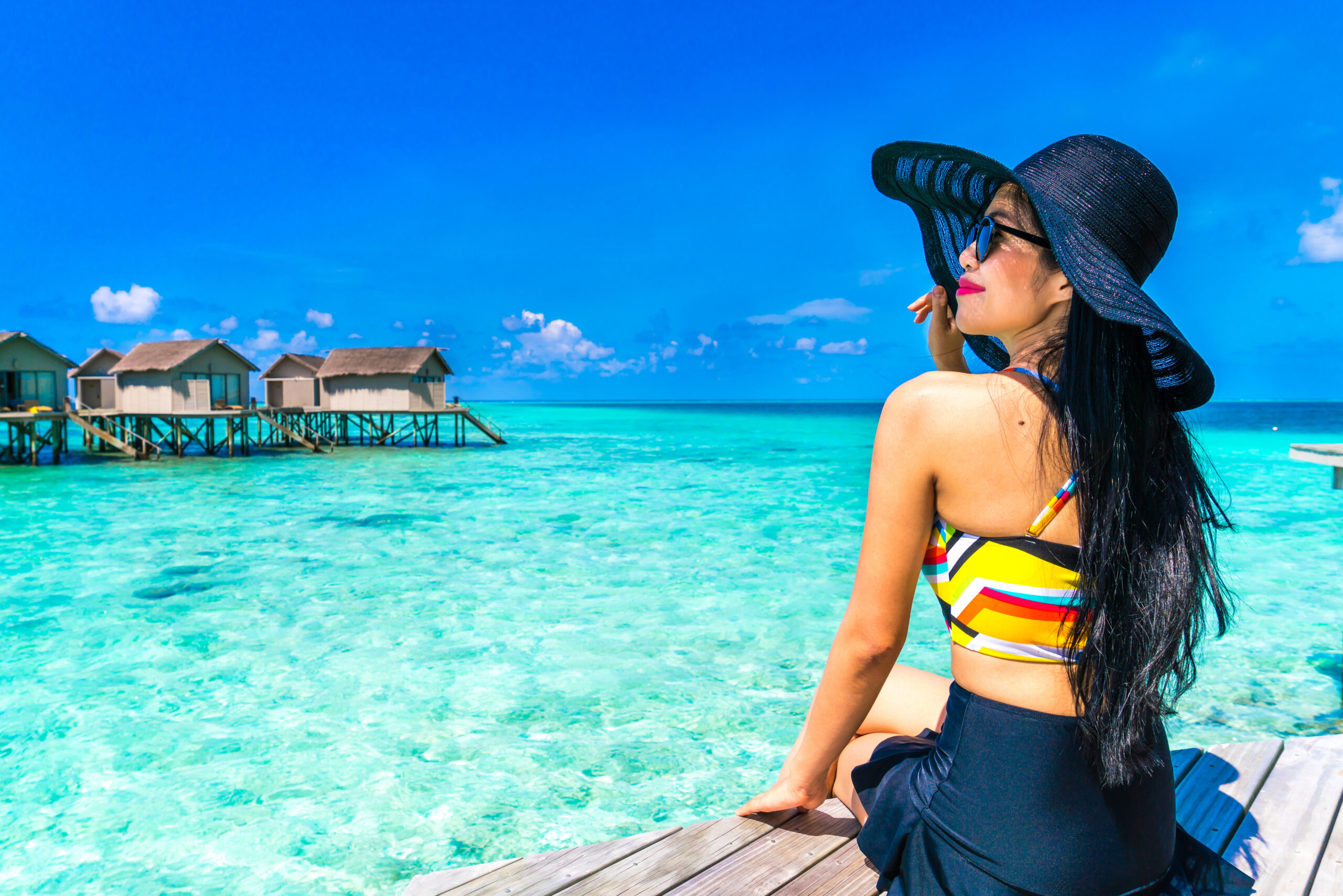 Portrait of happy young woman at beautiful water villa at Maldives island. Travel and Vacation. Outdoor shot